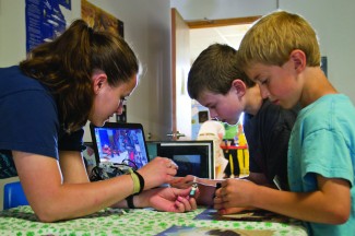 Abi Stomberg | Summer Arg Andrew Link, in blue, and his brother Joseph Link learn how to make toothbrush robots Saturday June 22. This display at the Palouse Science Fesitval was a part of the 4-H Robotics section.