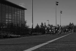The cross country teams warm up during practice Friday on the Kibbie SprinTurf.