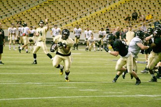 Nate Mattson | Argonaut  After taking a handoff, freshman running back Isaiah Saunders (left) dashes to the end zone during Friday's Silver and Gold Game at the Kibbie Dome.