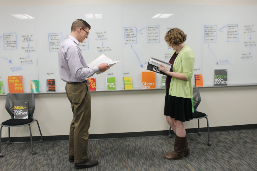 Diamond Koloski | The Argonaut University Libraries Associate Dean Ben Hunter (left) and Scholarly Communications employee Annie Gaines (right) read OpenStax's books as part of Open Education Week's "Textbook Petting Zoo" in the library Monday.