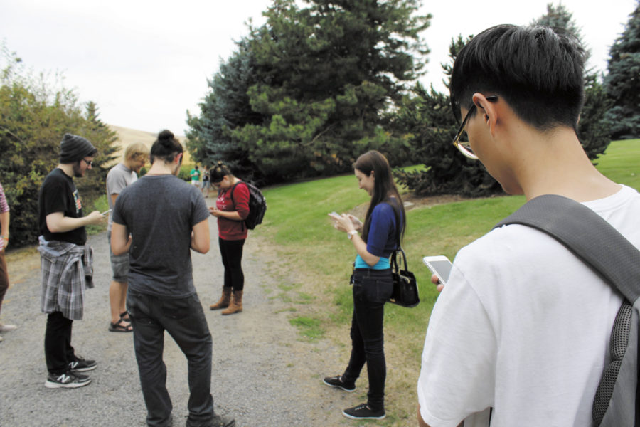 David Huson | Argonaut  Students attempt to take opposing Pokémon gyms on Tuesday along the arboretum trail. Pokémon gyms are areas where a player can station a digital creature of their own to control an area for their team.