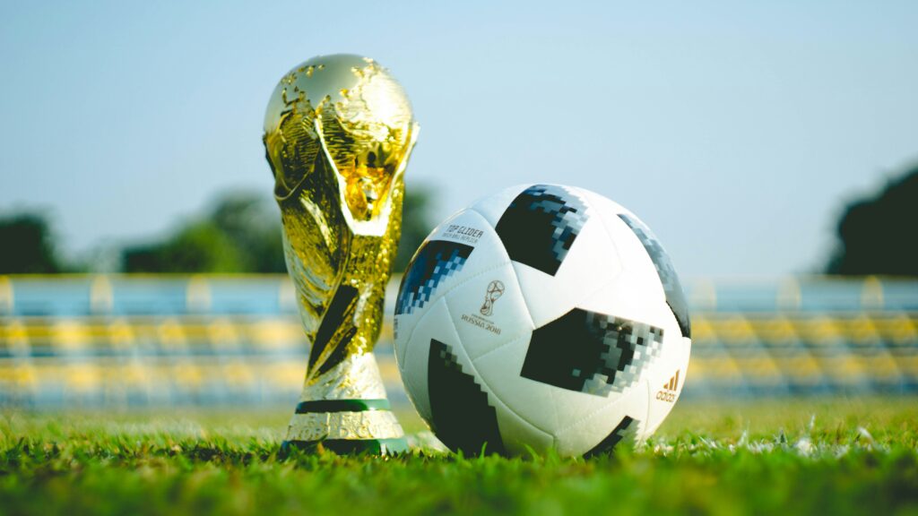 Soccer ball sits next to 2018 World Cup trophy | Fauzan Saari| Unsplash